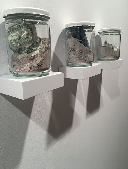 Instalación de cenizas by José Cosme, three sealed glass vessels displayed on individual white shelves