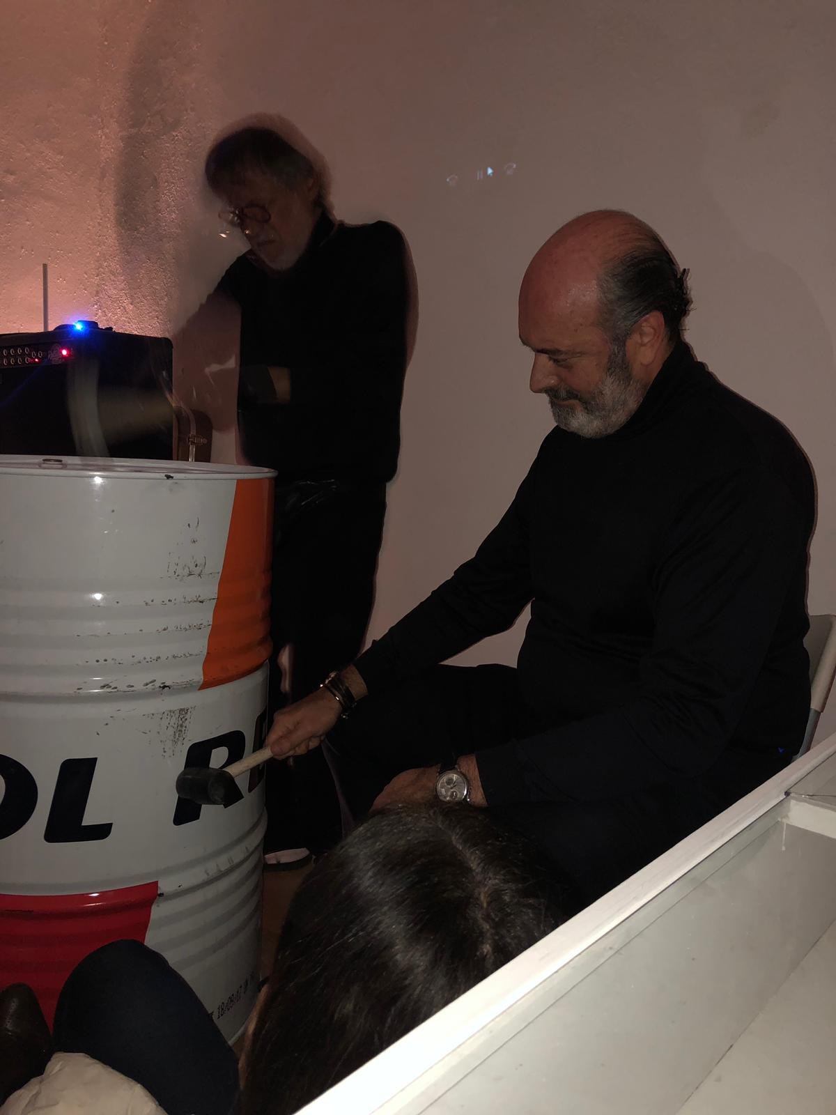 José Cosme during a performance action with industrial barrel